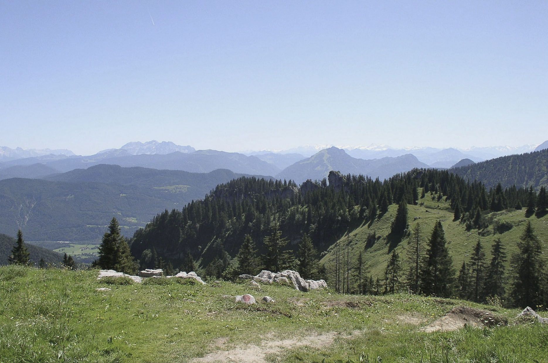 Blick über grüne Wiesen, Wälder und Berge bei der Kampenwand in den Chiemgauer Alpen. 