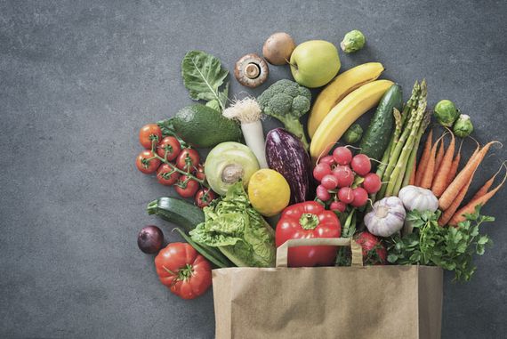 Das Bild zeigt eine Papiereinkaufstüte, die mit vielen Sorten Gemüse und Obst gefüllt ist